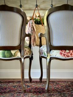 two chairs sitting side by side in front of a wall with flowers and plants on them