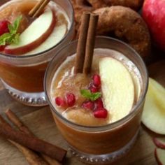 two glasses filled with apple cider and cinnamon sticks