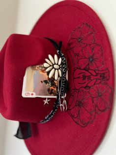 Be the life of the rodeo in this gorgeous boho red hat featuring a bull, poppies, and playful longhorns. Add this accessory to your wardrobe for a unique western touch. Western Cowgirl Hats, Cowboy Hats Decorated, Western Boutique Clothing, Cowboy Hat Crafts, Cowboy Boots Women Outfits, Red Cowboy Hat, Burned Hats, Cowboy Hat Design, Womens Fedora Hat