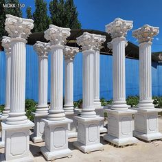 many white pillars are lined up against a blue wall