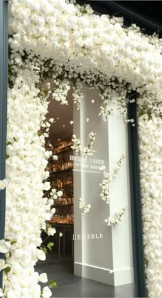 the entrance to a store decorated with white flowers