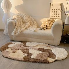 a living room with a white couch and brown rug