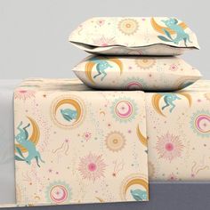 three pillow cases stacked on top of each other with unicorns and sunburst designs