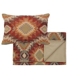 two pillows and a blanket on top of each other, one with an orange pattern