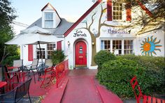 a red and white building with tables and chairs outside