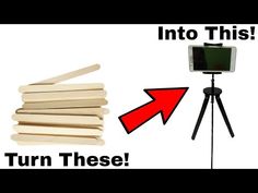 a tripod with a cell phone on it next to a pile of wooden sticks