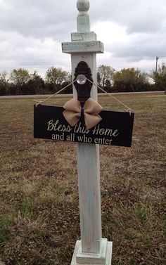 a wooden cross with a sign that says, blessing the home and all who enter