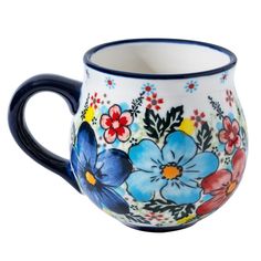 a blue and white coffee cup with flowers painted on the side, sitting in front of a white background