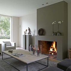 a living room filled with furniture and a fire place in front of a large window