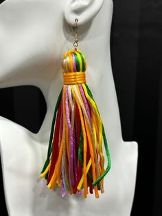 a white mannequin head with multicolored tassels on it's ear