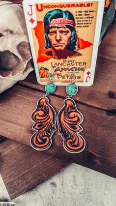 the earrings are made from metal and have an image of native american indians on them