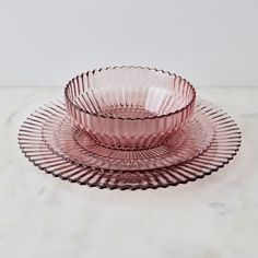 three pink glass dishes sitting on top of a marble counter