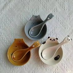 three small bowls with spoons in them sitting on a tablecloth covered table cloth