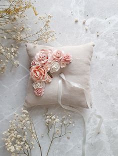 a white pillow with pink flowers on it next to some baby's breathflowers