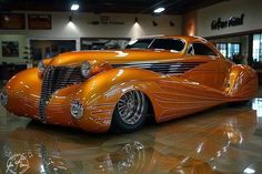 an orange car is parked in a showroom