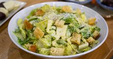 a white bowl filled with salad on top of a wooden table