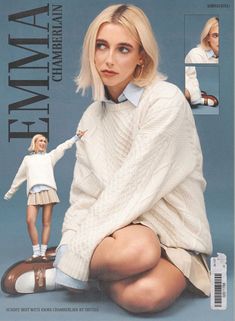 a woman sitting on the ground next to a doll wearing a white sweater and skirt