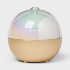 a white and beige vase with a glass dome on the top that is shaped like an egg