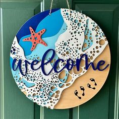 a welcome sign hanging on a door with sea shells and starfishs in the background