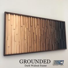 a wooden wall hanging on the side of a white wall with text grounded dark walnut frame