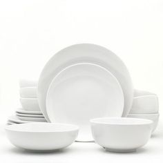 white dishes stacked on top of each other in front of a white background with one empty bowl