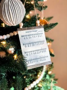 an ornament hanging from the top of a christmas tree with sheet music on it