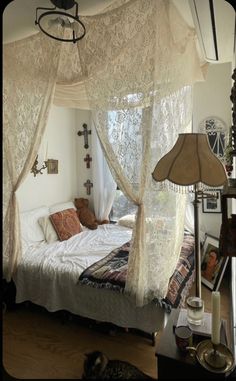 a white bed sitting under a window next to a lamp