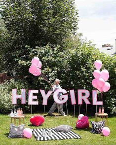 there is a sign that says hey girl in the grass with pink balloons on it