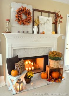 a living room with a fire place filled with pumpkins and other fall decorations on the mantle