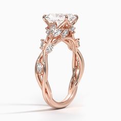 a rose gold engagement ring with an oval diamond center and twisted vine design on the band