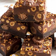 a pile of brownies with nuts on top