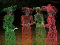 three women in dresses and hats standing next to each other