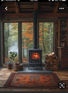 a wood burning stove sitting inside of a living room next to a large glass window