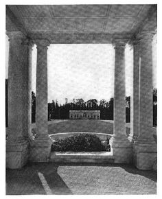 an old black and white photo of a building with columns in the center, surrounded by trees