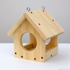 a wooden birdhouse with two holes in the roof