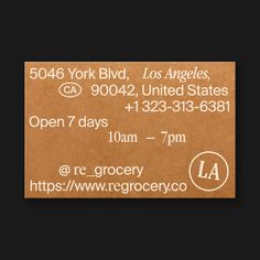 a brown business card with the words la on it in white lettering and an orange circle