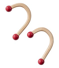 two wooden hooks with red balls attached to the handles, one is shaped like an oar