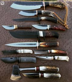 several knives are lined up on a table with different types of knives in them,