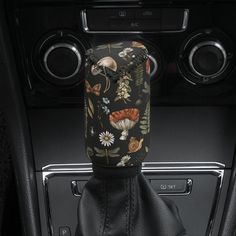 the interior of a car with a black leather seat cover and floral print on it