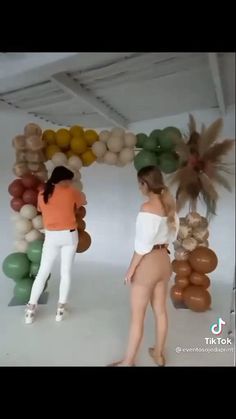 two women are standing in front of balloons