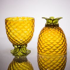 two yellow glass vases sitting next to each other