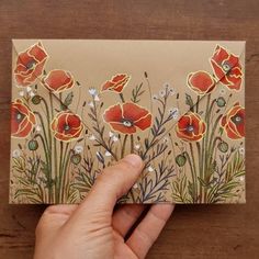 a hand holding up a card with flowers on it