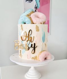 there is a cake that says oh baby on it with donuts and sprinkles