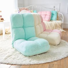 two different colored chairs sitting on top of a rug