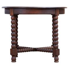 an old wooden table with turned legs and bead work on the top, isolated against a white background