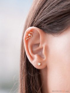 a close up of a person's ear with gold stars on it