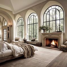 a large bedroom with arched windows and a fireplace