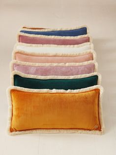 five different colored pillows stacked on top of each other in the shape of a rectangle