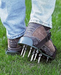 a person standing in the grass with some spikes on their feet and one foot sticking out