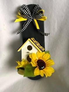 a birdhouse with sunflowers and a bow on it's head sitting in front of a white background